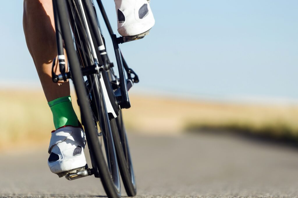 Close-up of the foot of a young man cycling.