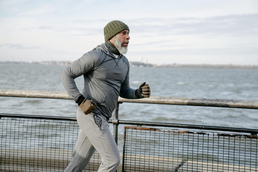 A man in his 60s running along a seafront